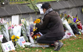 Flowers are laid at the special wall set up beside the Christchurch Botanical gardens.
