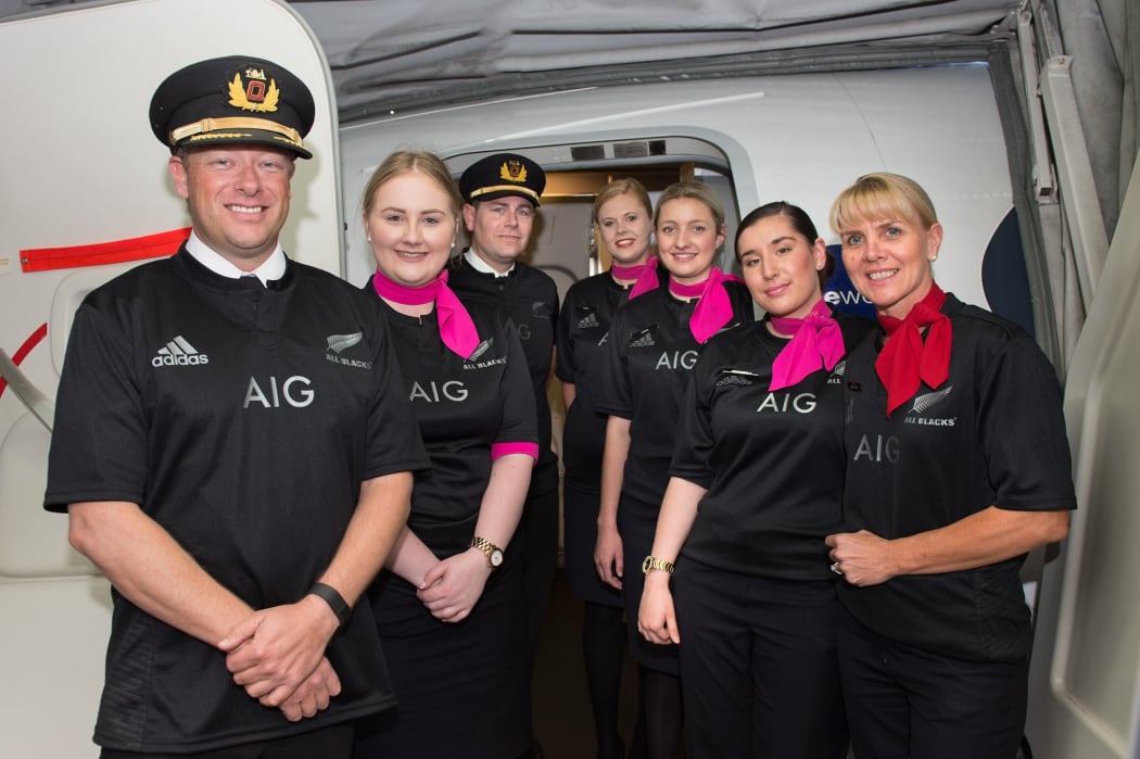 The crew on the Sydney-to-Auckland flight wearing All Blacks gear after Australia lost to New Zealand in the RWC 2015 final.