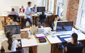 Wide Angle View Of Busy Design Office With Workers At Desks - open plan office