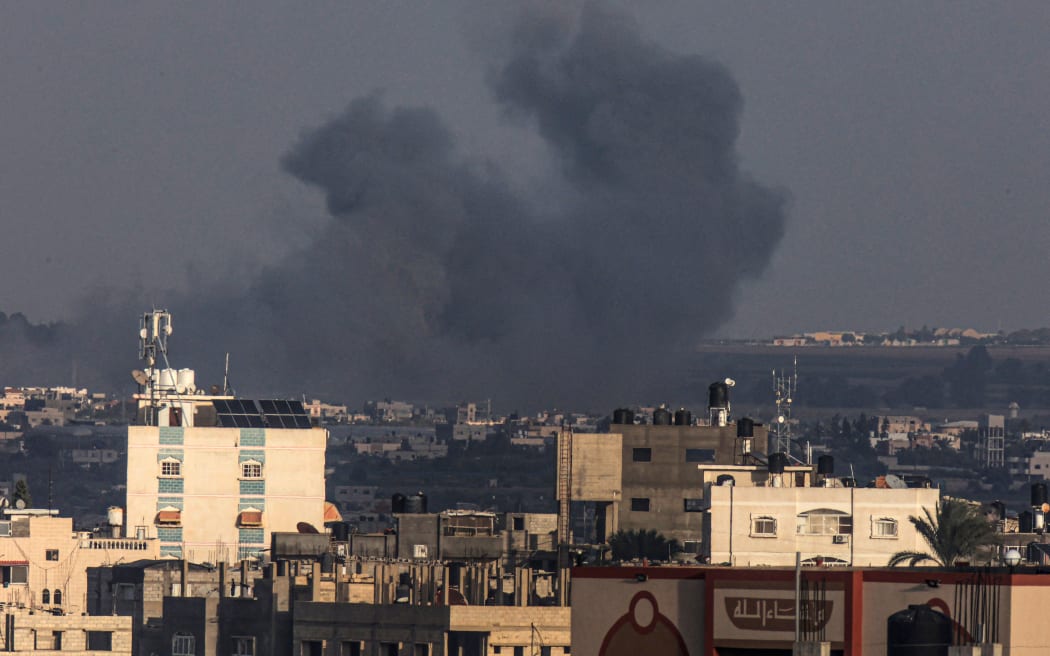 A picture taken from Rafah shows smoke billowing over Khan Yunis during Israeli bombardment in the southern Gaza Strip on 24 December, 2023, amid ongoing battles between Israel and Hamas.