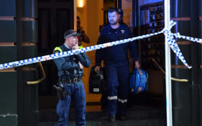 Police investigate inside a building near the scene of a knife rampage in Sydney.