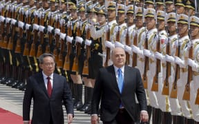Russian Prime Minister Mikhail Mishustin (C) and Chinese Premier Li Qiang attend a welcoming ceremony in Beijing on May 24, 2023.