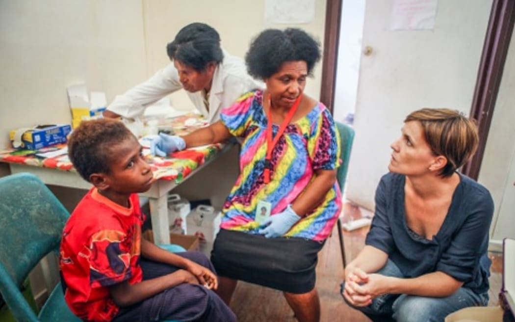 Dr Leanne Robinson (far right) with patient Jonathan (far left), who is being tested for malaria by Nursing Officer Kay Kose (second from left) and microscopist Barbara Sambre (second from right).