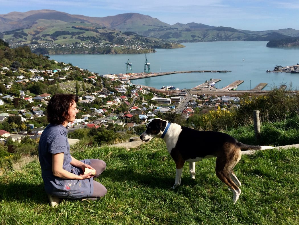 Hannah Beehre and her dog Scout with the view over Lyttelton