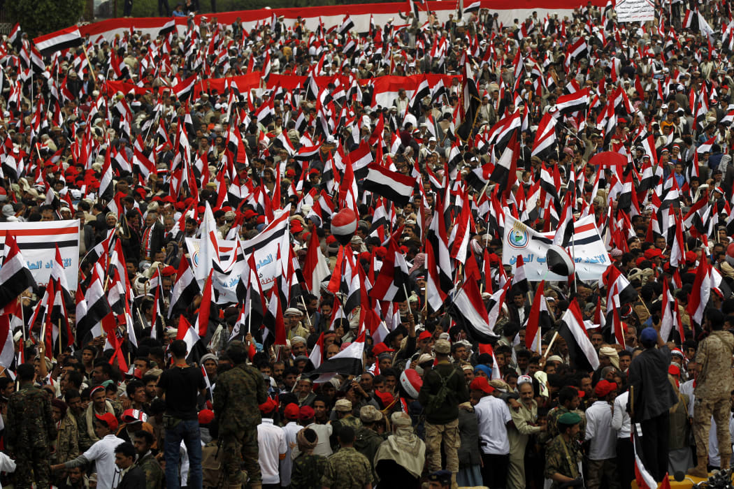 Yemenis waving the national flag during the protest.