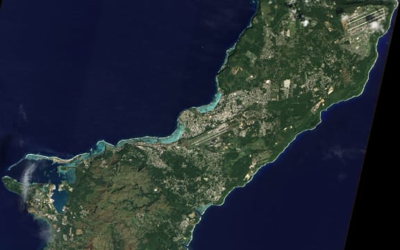 A satellite image of Guam. Andersen Air Force base is in the top-right corner, while the Naval base is on the left.