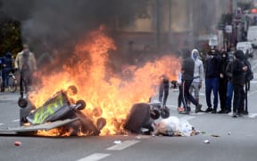 People watch a fire on the Pont Neuf, in Toulouse, southern France as part of the fourth day of mobilization of high school students in the wake of the movement of "yellow vests".