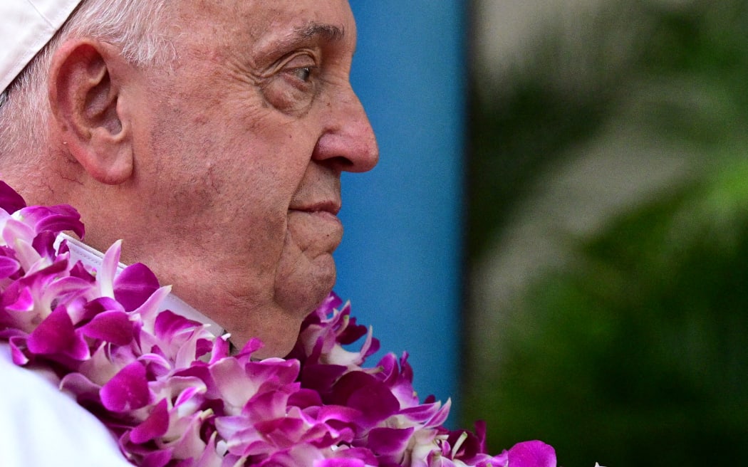 Pope Francis wears a flower garland as he arrives for an interreligious meeting with young people at the Catholic Junior College in Singapore on September 13, 2024. Singapore is the last stop on the pope's 12-day, four-nation Asia-Pacific trip aimed at boosting the Catholic Church's standing in the world's most populous region. (Photo by Tiziana FABI / AFP)