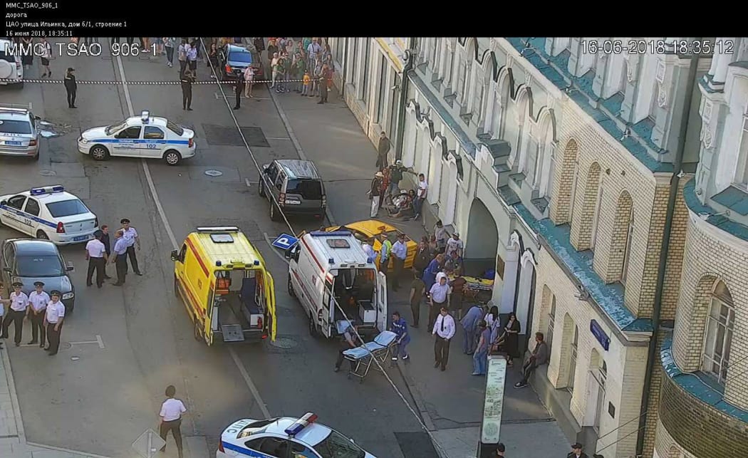 A handout CCTV picture released by the Moscow Municipal Traffic Regulation center shows Russian police officers and paramedics working at the scene after a taxi drove into a crowd injuring seven people.