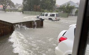 Waves of water hit Tracey Tasovac’s front yard on the day of the floods last year