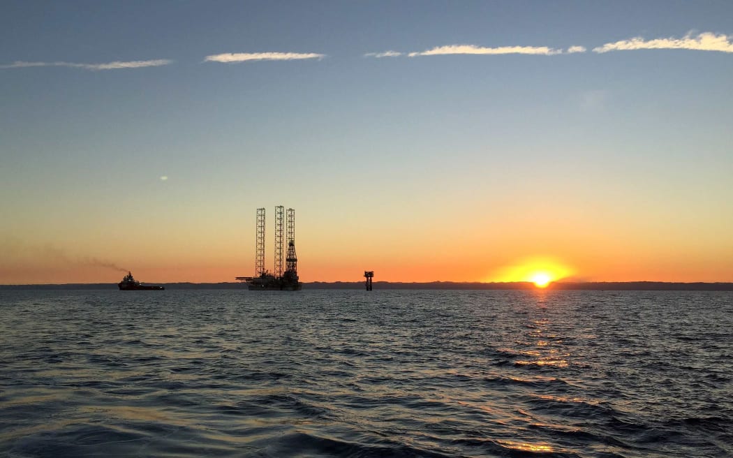 Pohokura rig in the distance with the sun just rising over the sea