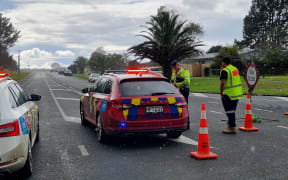 Police block the road following a double homicide in Ruakākā.