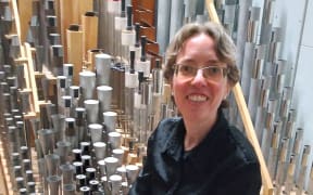 Isabelle Demers sitting amongst some of the pipes of the Auckland Town Hall Organ