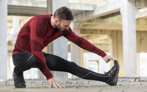 Athletic, muscular man stretching. out and warming up for a workout