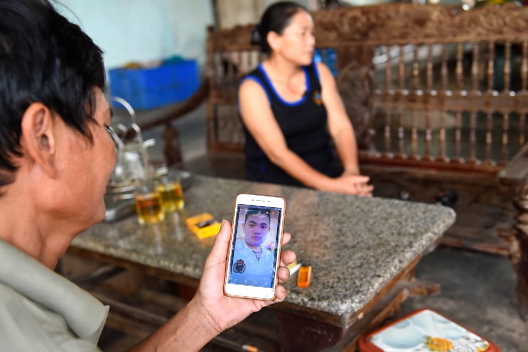 Hoang Lanh, father of 18-year old Hoang Van Tiep who is feared to be among the 39 people found dead in a truck in Britain, looks at his son's photograph on his phone at their house in Dien Thinh commune of Vietnam's Nghe An province on October 28, 2019