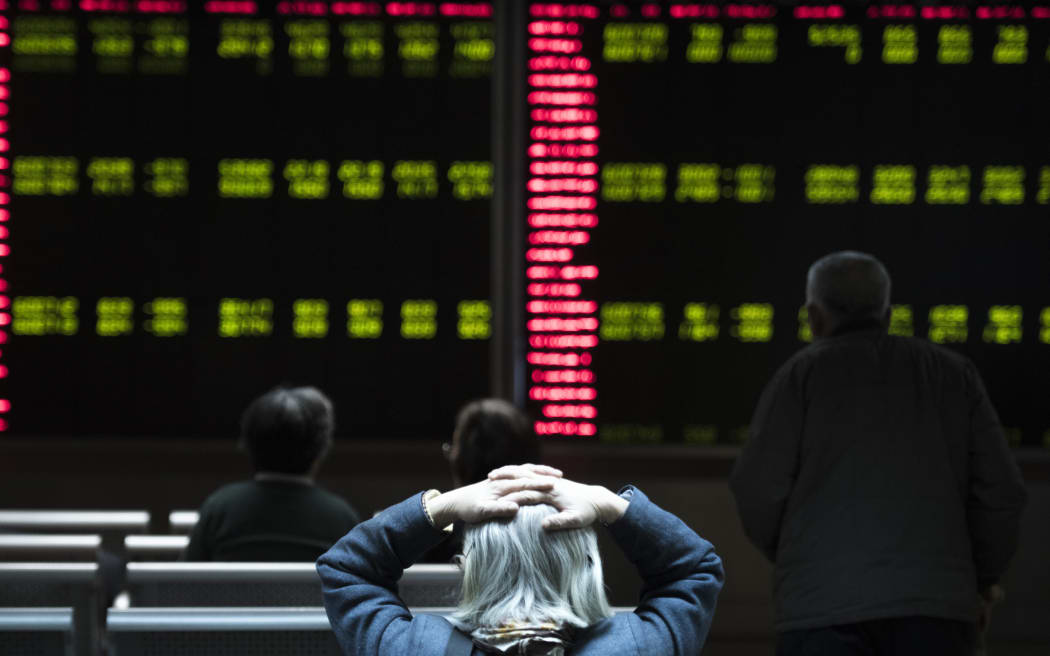 Chinese investors watch stock market movements at a securities company in Beijing.