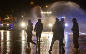 Police officer use water cannon as they clash with nationalist youths in the Springfield Road area of Belfast on April 8, 2021 as disorder continued in the Northern Ireland capital following days of mainly loyalist violence.