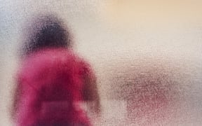 Silhouette of sad girl behind frosted glass. (Photo by IGOR STEVANOVIC / SCIENCE PHOTO / IST / Science Photo Library via AFP)