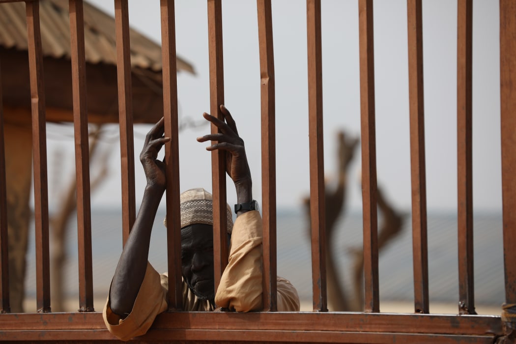 A parent waits outside the Government Science Secondary school in Kankara, in northwestern Katsina State, Nigeria on December 16, 2020.