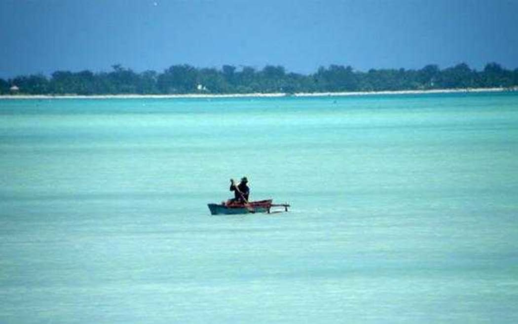 A man paddles his canoe in Kiribati