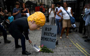 A man wearing a mask of Boris Johnson protests outside Downing Street over Parliament's suspension.