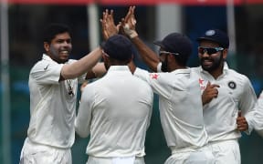 India's Umesh Yadav, left, celebrates the wicket of New Zealand's Martin Guptill with teammates during the second day of the first Test at Green Park Stadium in Kanpur on 23 September 2016.