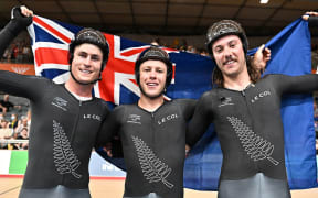 Corbin Strong (centre) of New Zealand celebrates with teammates, Campbell Stewart and George Jackson after winning Gold in the Men's Track Cycling 15km Scratch Race.