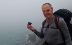 Bruce Hopkins with the urns of ashes at Cape Reinga, at the start of his journey