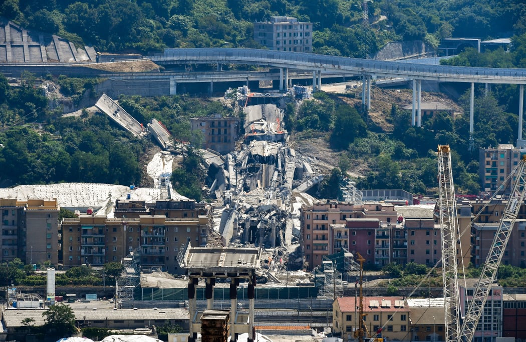 A general view shows the bridges' deck debris and rubble (Rear C) among evacuated buildings after explosive charges blew up the eastern pylons of Genoa's Morandi motorway bridge on June 28, 2019 in Genoa.