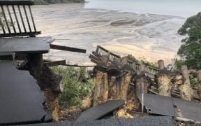 Badly damaged road overlooking the beach at Titirangi.