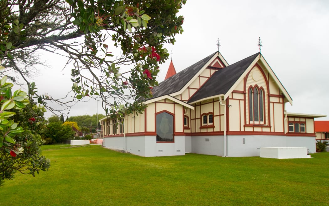Green grass yard behind Saint Faiths combination Catholic and Maori church, across the Second World War cemetery, Rotorua, North Island, New Zealand, November 3, 2017. (Photo by Smith Collection/Gado/Getty Images)
