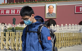 A man bows in front of Tiananmen Gate during a three minute national memorial to commemorate people who died in the COVID-19 coronavirus outbreak.