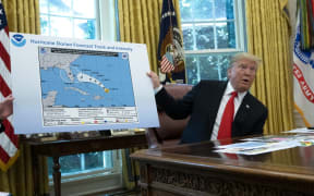United States President Donald J. Trump holds a map that appears to show the course of Hurricane Dorian going through part of Alabama.