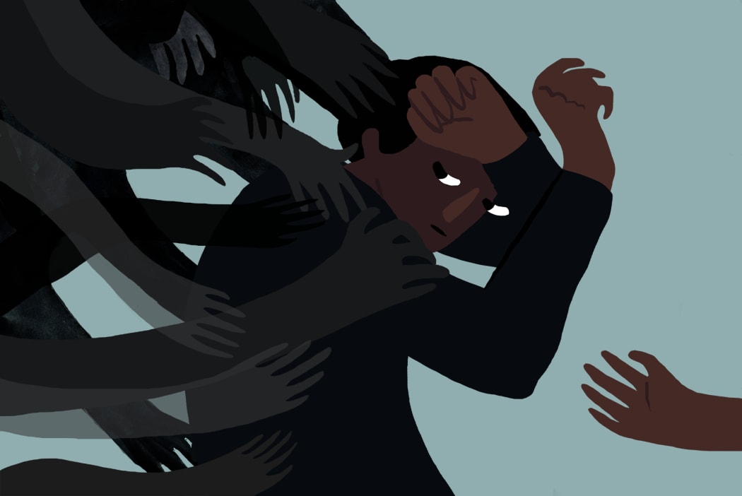 An illustration shows a young man caught in the grip of dark hands, illustrating mental health and suicide prevention.