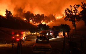 Firefighters conduct a controlled burn to defend houses against flames from the Ranch Fire.