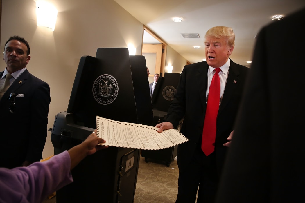 Donald Trump hands in his board of election card as he votes at his local polling station in New York's primary on April 19, 2016 in New York City.