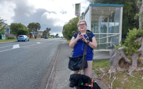 Bonnie Mosen waits for the bus from Grenada Village with her guide dog Eclipse.