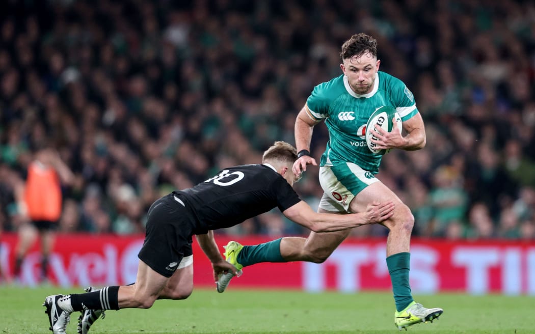 Ireland’s Mack Hansen tries to evade All Black Damian McKenzie in a test match at Aviva Stadium in Dublin, 8 November, 2024.