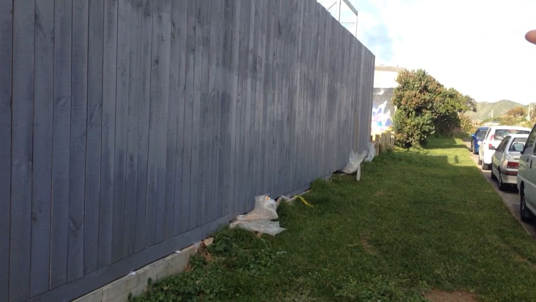Plastic waste jammed under a neighbouring fence.