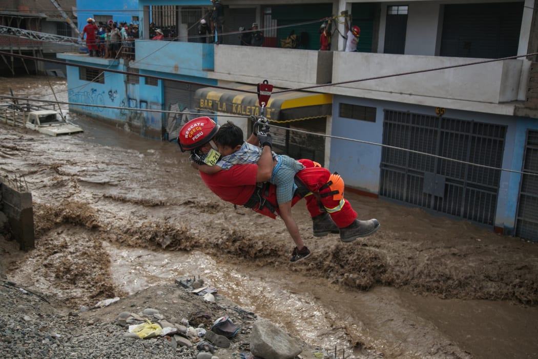 LIMA, PERU - MARCH 17 : Agents of the Peruvian National Police rescue people trapped in buildings due to the flooding of the Rimac and Huaycoloro rivers, in Lima, Peru on March 17, 2017.