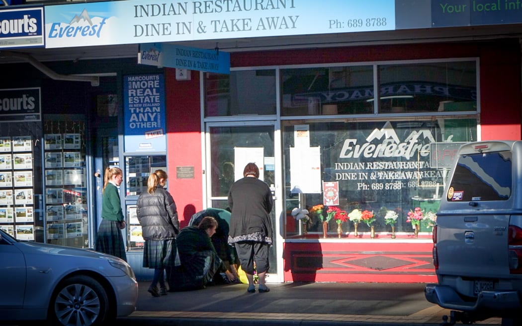 Waimate residents paying tribute to the Kafle family outside their restaurant.