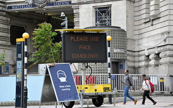 A sign tells passengers to 'wear a face covering' at Waterloo train station in central London during the Covid-19 pandemic