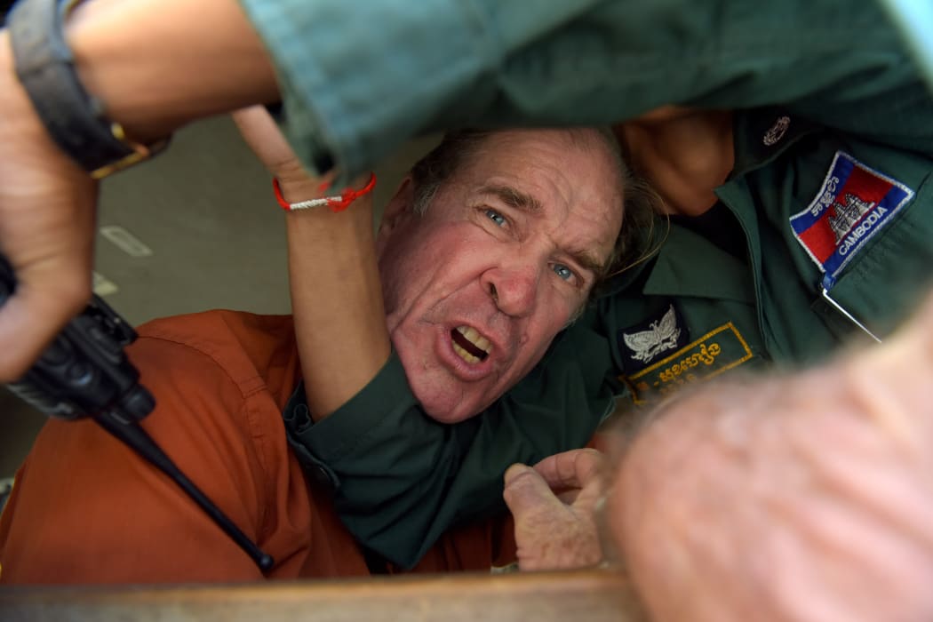 Australian filmmaker James Ricketson reacts as he attempts to speak to journalists from a prison vehicle after his verdict at the Phnom Penh court.