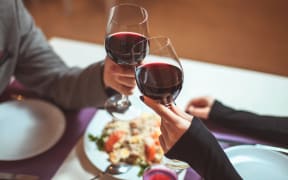 Couple sharing a meal and a glass of wine.