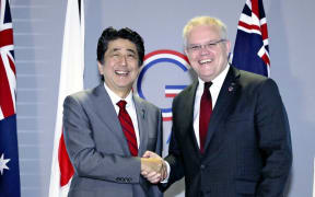 Australias Prime Minister Scott Morrison shakes hands with Japan's counterpart Shinzo Abe ahead of their summit meeting during the G7 summit meeting in Biarritz.