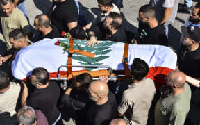 Mourners carry the flag-draped casket of Lebanese Reuters video journalist Issam Abdallah, who died on 13 October during Israeli shelling at the Alma al-Shaab border village with Israel.