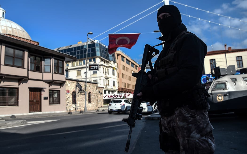 A Turkish special force police officer stands guard at ortakoy district near the Reina night club in Istanbul.