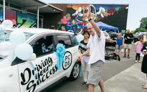 Harry Doig, Puketāpapa Local Board chairman, cutting the ribbon for one of Puketāpapa Community Driving School’s vehicles on its opening day.
