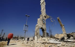 Civilians carry belongings recovered from an area near Damascus, after soldiers loyal to Syria's President Bashar al-Assad regained control from rebel fighters in October 2014.