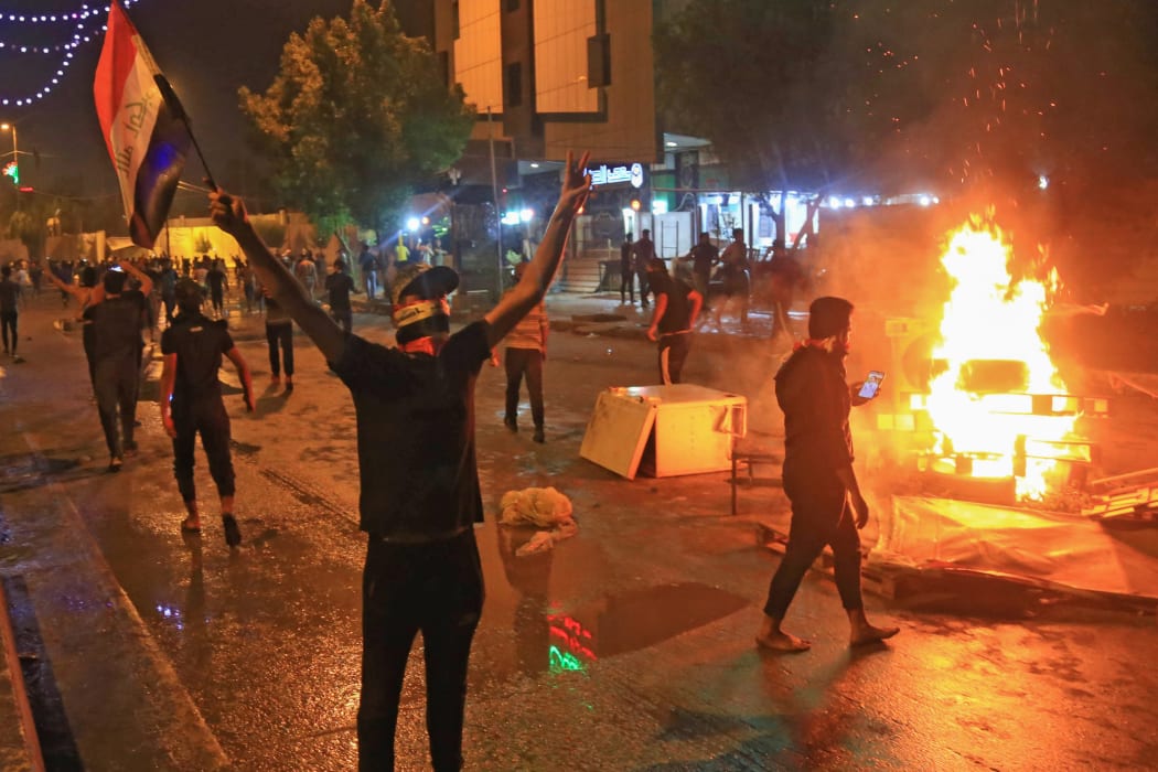 Iraqi protesters burn items to block the road during clashes with security forces following an anti-government demonstration in the Shiite shrine city of Karbala, south of Iraq's capital Baghdad.